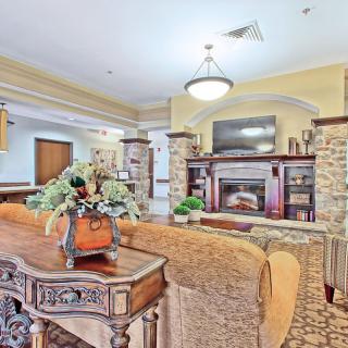 A cozy living room featuring a fireplace, large TV, and elegant decor.