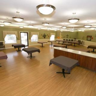 A spacious, well-lit dining room with several tables and chandeliers.