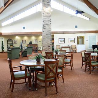 Spacious lounge area with tables and chairs under a high ceiling.