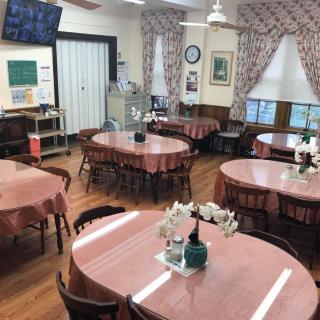 A cozy restaurant interior with round tables covered in pink tablecloths.
