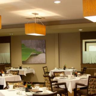 A cozy restaurant dining area with neatly arranged tables and modern lighting.