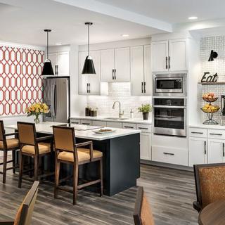 A modern kitchen with white cabinetry, a central island, and stainless steel appliances.