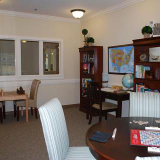 A well-organized office space with a desk, bookshelves, and a table with chairs.