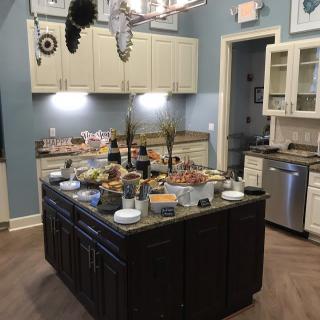 A kitchen featuring a central island set up with a buffet of various foods.