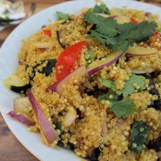 A vibrant quinoa salad with assorted vegetables and fresh herbs.