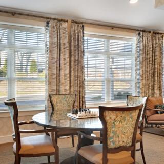 A cozy dining area with elegant chairs and a large window view.
