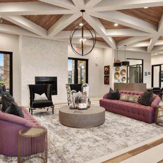A spacious and modern living room with stylish furnishings, featuring a unique chandelier, comfortable sofas, and a central coffee table.