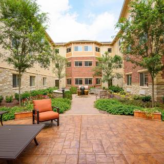 A beautifully landscaped apartment courtyard with seating areas and greenery.