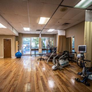 A well-equipped physical therapy room with exercise machines and a spacious layout.