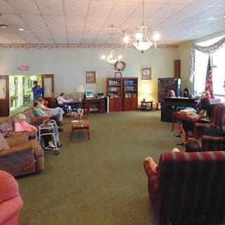 A cozy lounge area in a nursing home with seniors relaxing and socializing.
