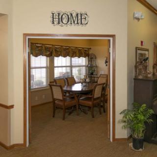 A cozy dining room interior with a table, chairs, and windows, labeled 'Home'.