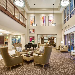 A spacious and elegantly designed hotel lobby with comfortable seating and decorative chandeliers.