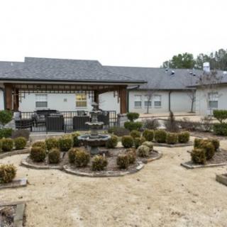 A landscaped garden area with a fountain in front of a building.