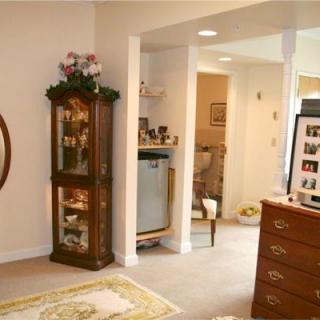 A cozy living room with elegant furniture and decor, featuring a cabinet, mirror, and wooden drawers.