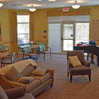 A cozy living room with comfortable seating and a piano.