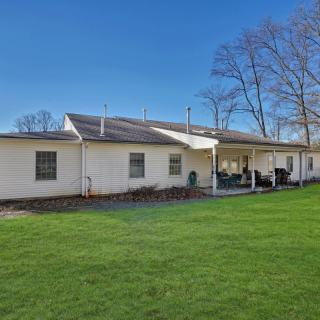 A view of a house with a spacious backyard and well-maintained lawn under a clear blue sky.