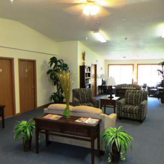 A cozy living area with comfortable seating, tables, and decorative plants.