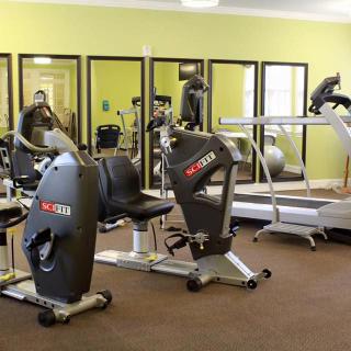 A well-equipped gym with various exercise machines including recumbent bikes and treadmills.