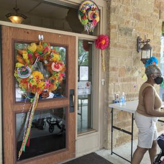 A vibrant entrance adorned with colorful floral decorations, welcoming visitors on a sunny day.