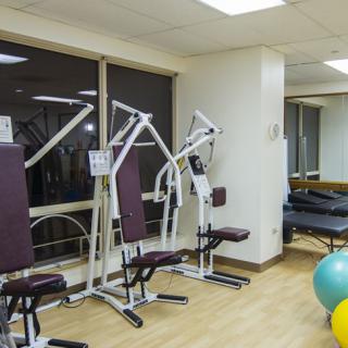 A well-equipped gym room with exercise machines and fitness balls.