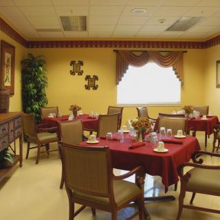A cozy dining room with neatly arranged tables and chairs, featuring warm interior decorations.