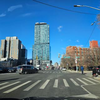 A vibrant cityscape showcasing a modern skyscraper against a clear blue sky.
