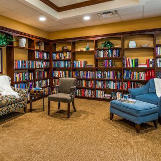 A cozy library corner with bookshelves filled with books and comfortable seating.