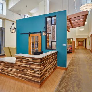 A modern reception area featuring a striking blue wall and natural wood elements.