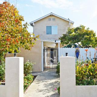 A two-story house with a garden and pathway leading to the entrance.