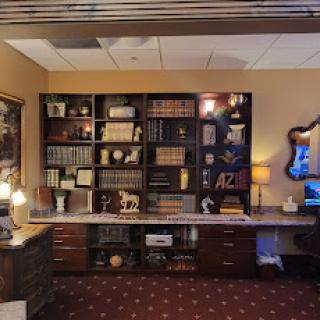A well-organized office space featuring a bookshelf filled with various books and decorative items.