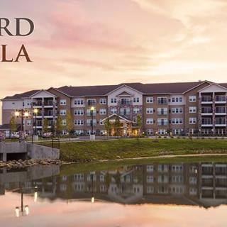 A striking view of a large building reflected in a lake at sunset.
