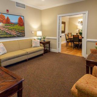 A cozy living room with comfortable seating and vibrant artwork on the wall.