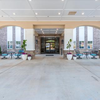 Entrance area of a building with outdoor seating and potted plants.