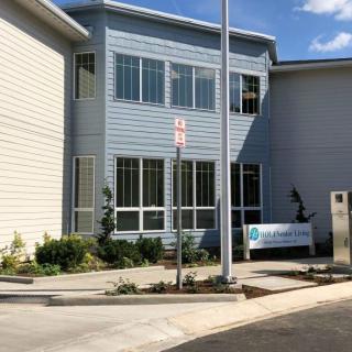 A modern office building with large windows and a landscaped entrance.