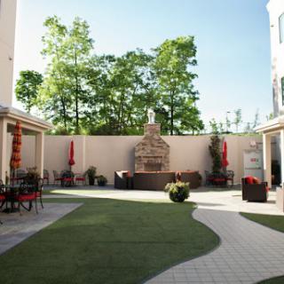 A serene courtyard featuring a fountain, surrounded by greenery and seating areas for relaxation.