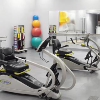 A therapy gym with specialized workout machines and colorful exercise balls.