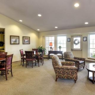 A cozy living room with multiple seating arrangements and large windows.