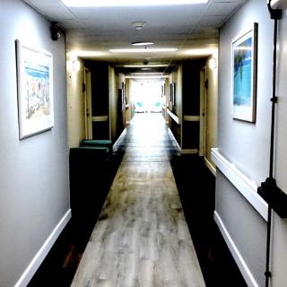 A bright hallway with framed artwork on the walls.