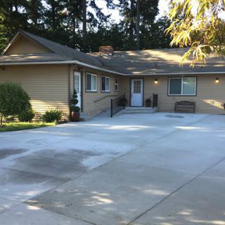 A cozy residential home with a spacious driveway and well-maintained front yard.