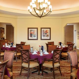 Elegant dining room with arranged tables and a chandelier.