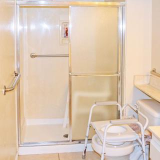 An accessible bathroom featuring a sliding door shower and a walker.