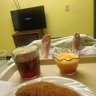 A cozy hospital room with a meal and some entertainment.