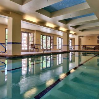 A serene indoor swimming pool with ample natural light filtering through large windows.