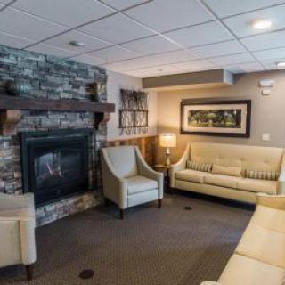 A cozy living room with a stone fireplace, comfortable seating, and modern decor.