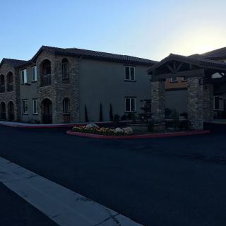 A view of a hotel building during the evening with landscaped surroundings.