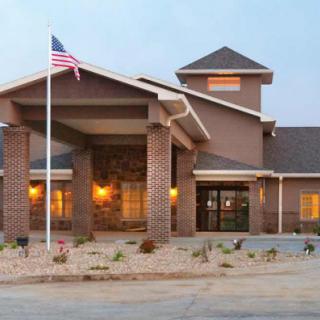 A cozy hotel entrance with brick pillars and an American flag.