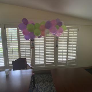 A colorful display of balloons hanging over a table, adding a festive touch to the room.