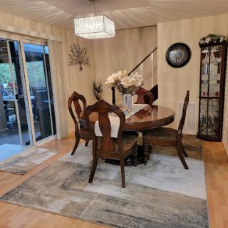 A cozy and elegantly designed dining room featuring a wooden table, comfortable chairs, and tasteful decor.