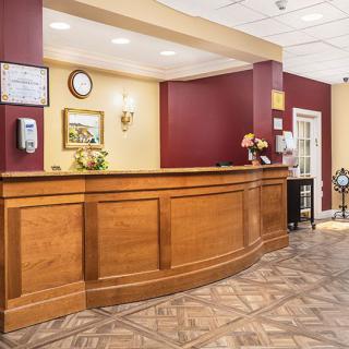 A welcoming hotel reception area with a wooden counter and warm lighting.