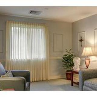 A cozy living room with a sofa, lamp, and curtains.